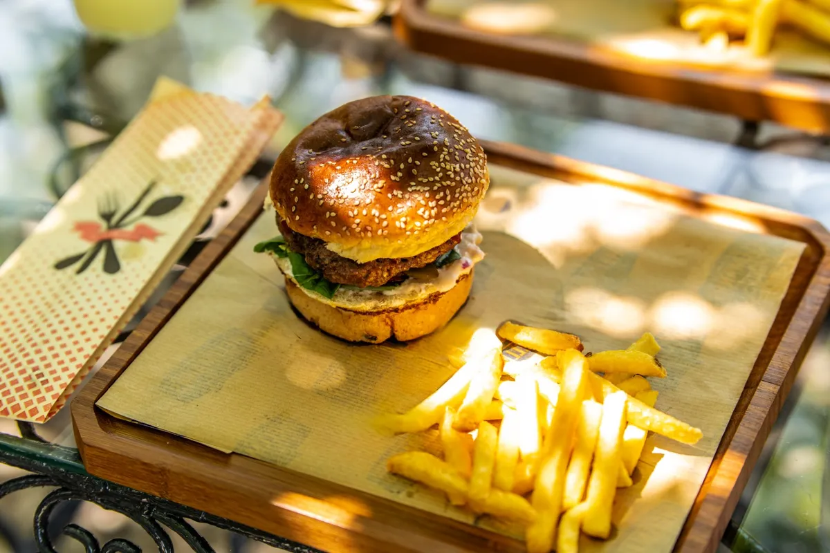 Ahşap tahtada susamlı burger ve patates kızartması